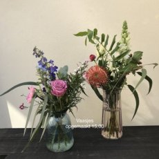 Glazen vaas opgemaakt met bloemen
